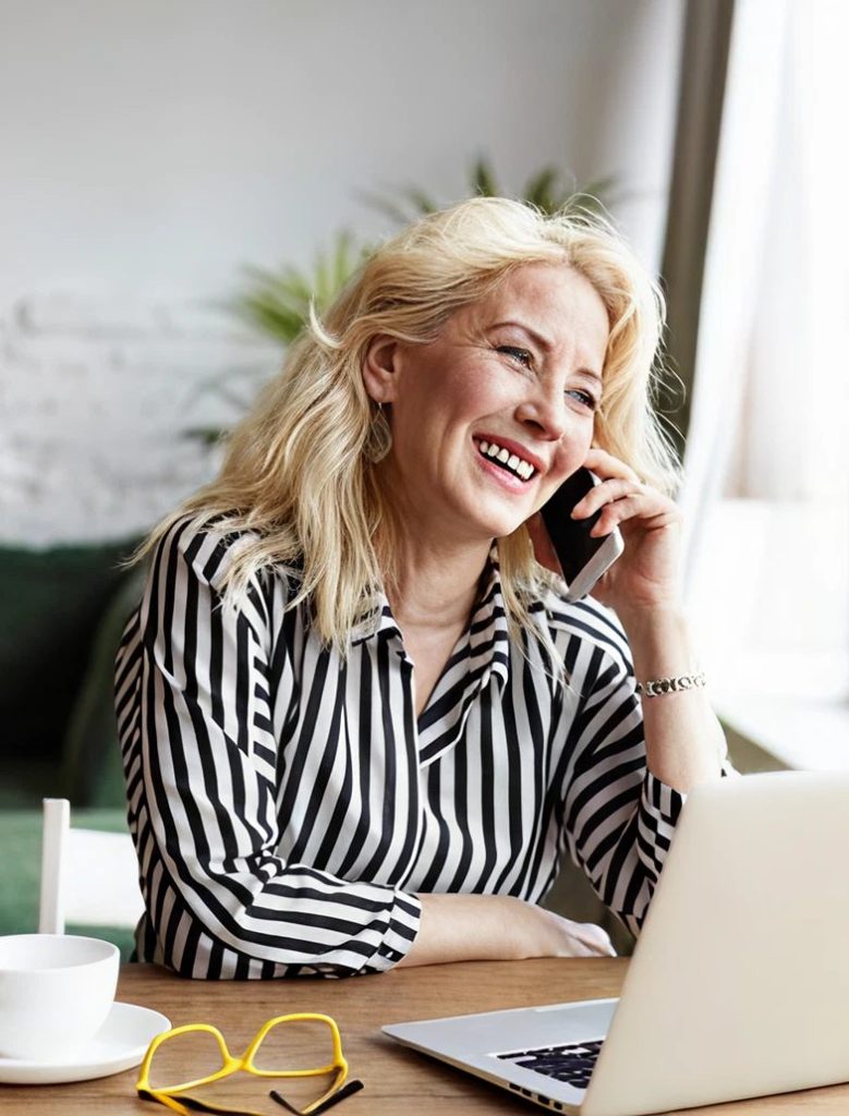 A homeowner on the phone at her laptop, planning a painting project